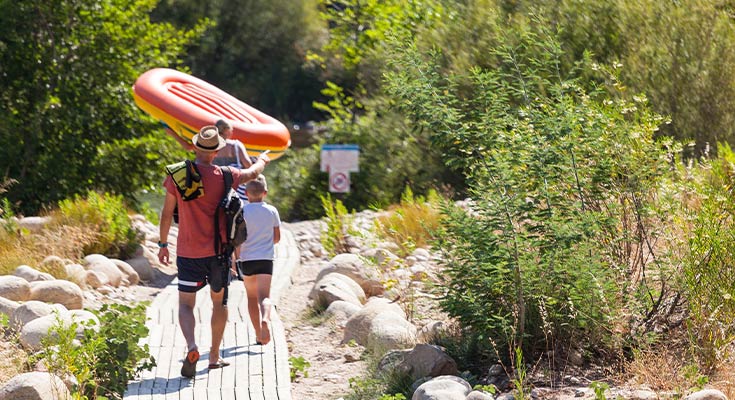 famille transportant son bateau gonflable à la rivière