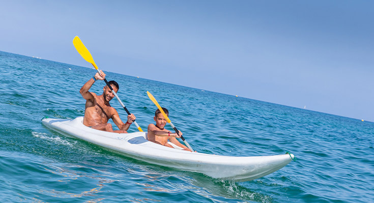 un père et son fils faisant du kayak de mer